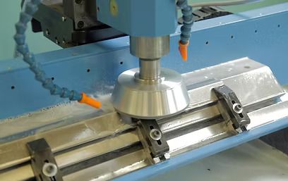 Una máquina está cortando un trozo de metal sobre una mesa.