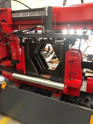 Una máquina roja y gris está sentada sobre una mesa en una fábrica.