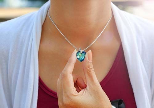 Una mujer lleva un collar con un colgante en forma de corazón.