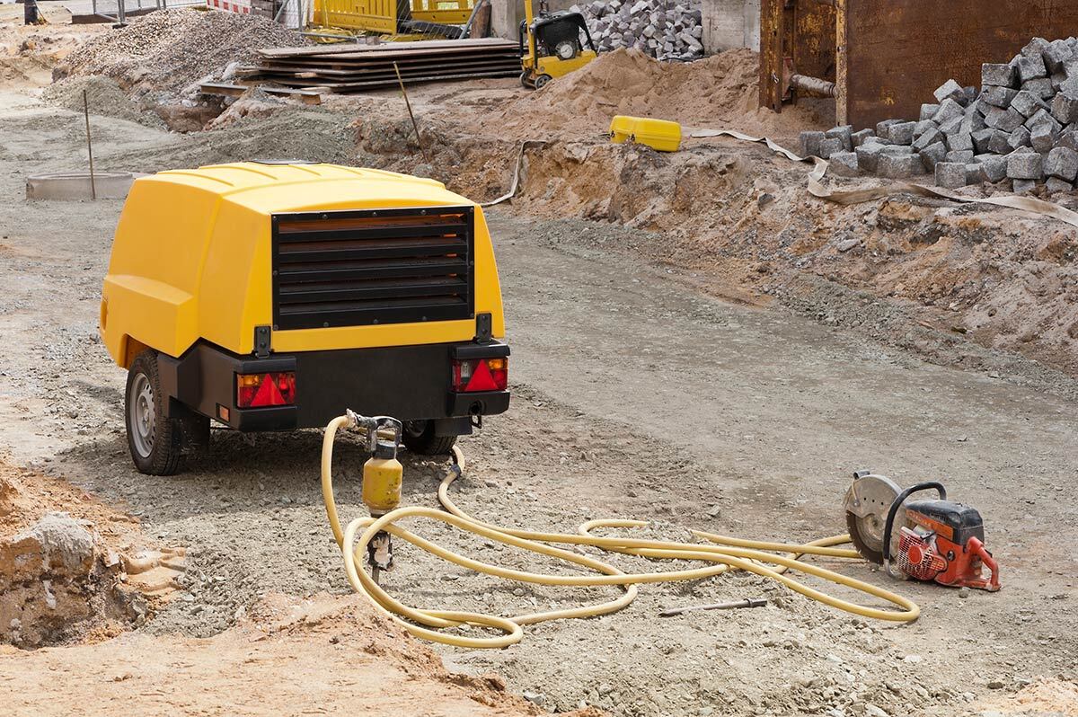 Compresseur jaune relié à une disqueuse