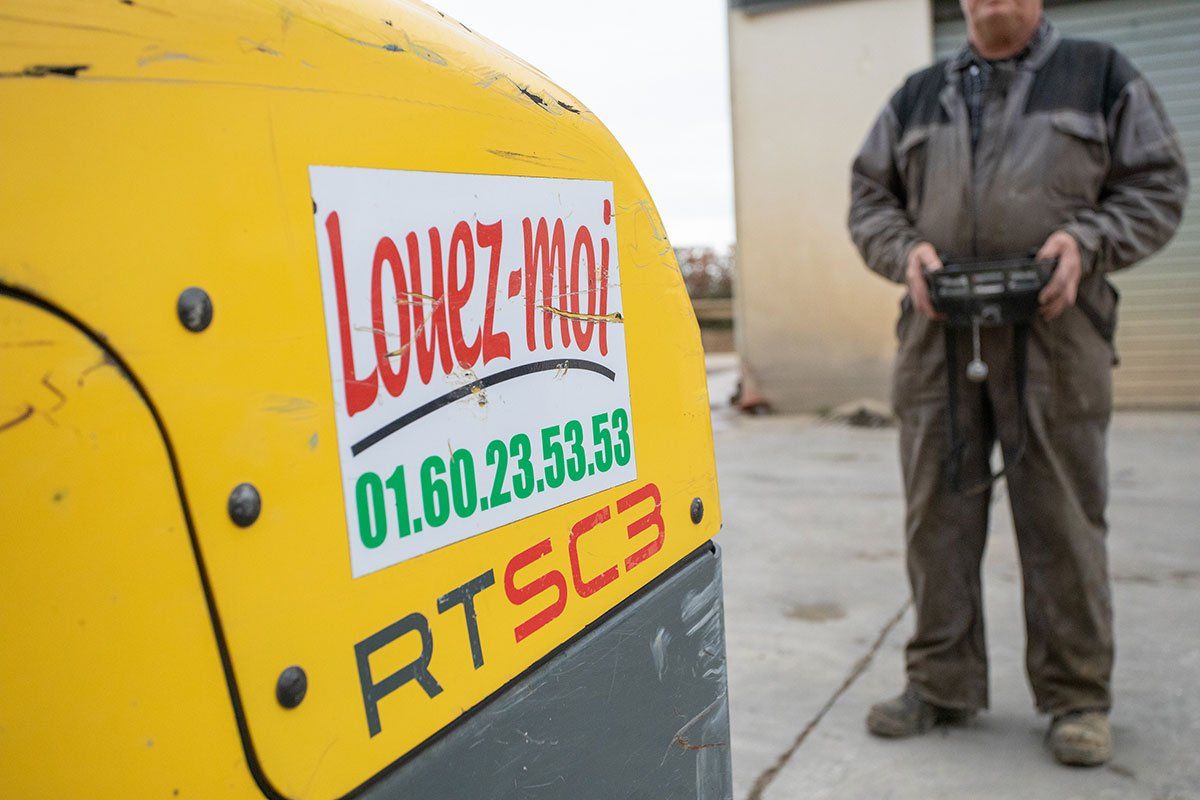 Un technicien avec une manette pour contrôler une machine