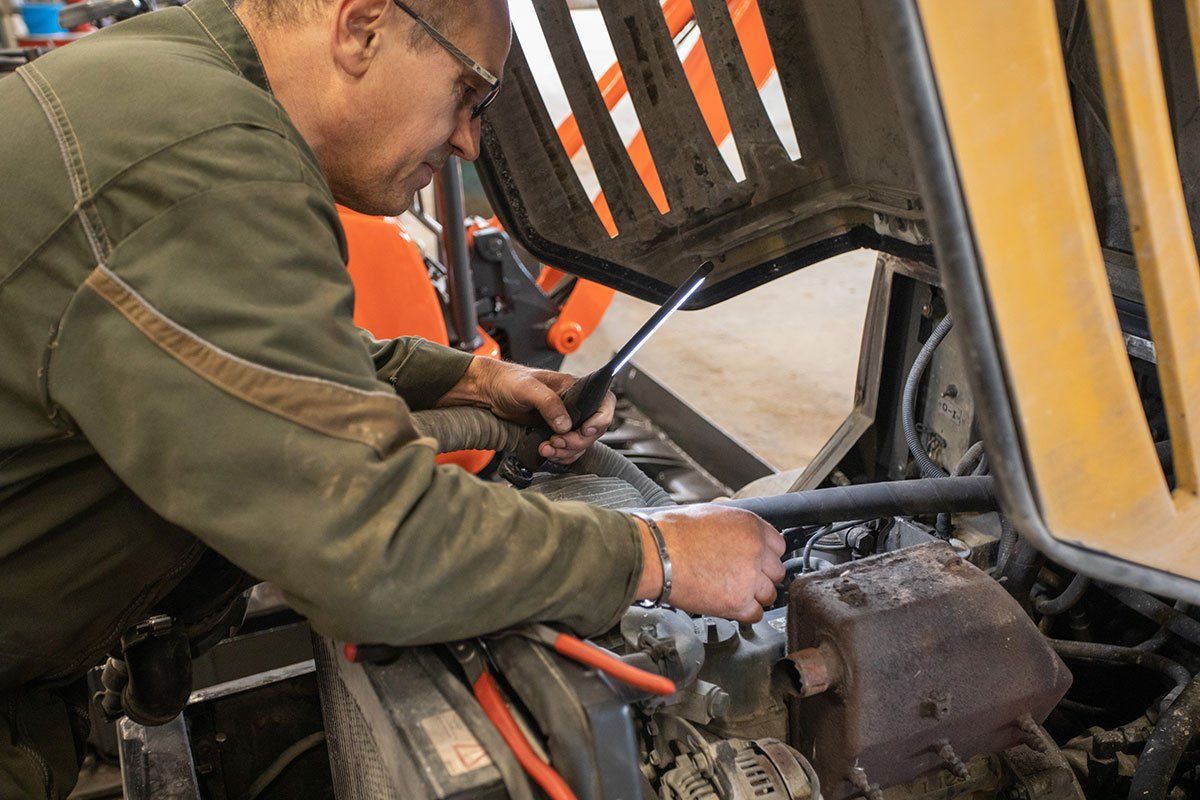 Un technicien cherche une panne sur un engin de BTP