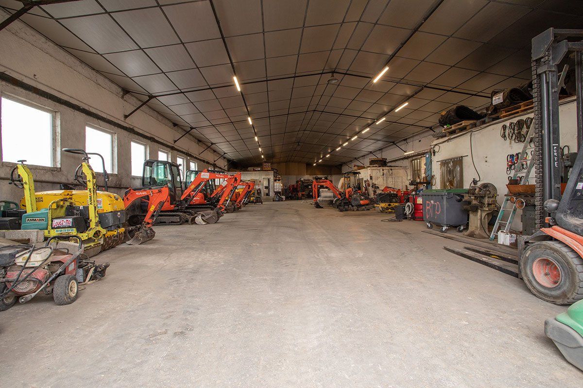 Intérieur du bâtiment de BTP Distribution avec des engins de TP de toutes sortes