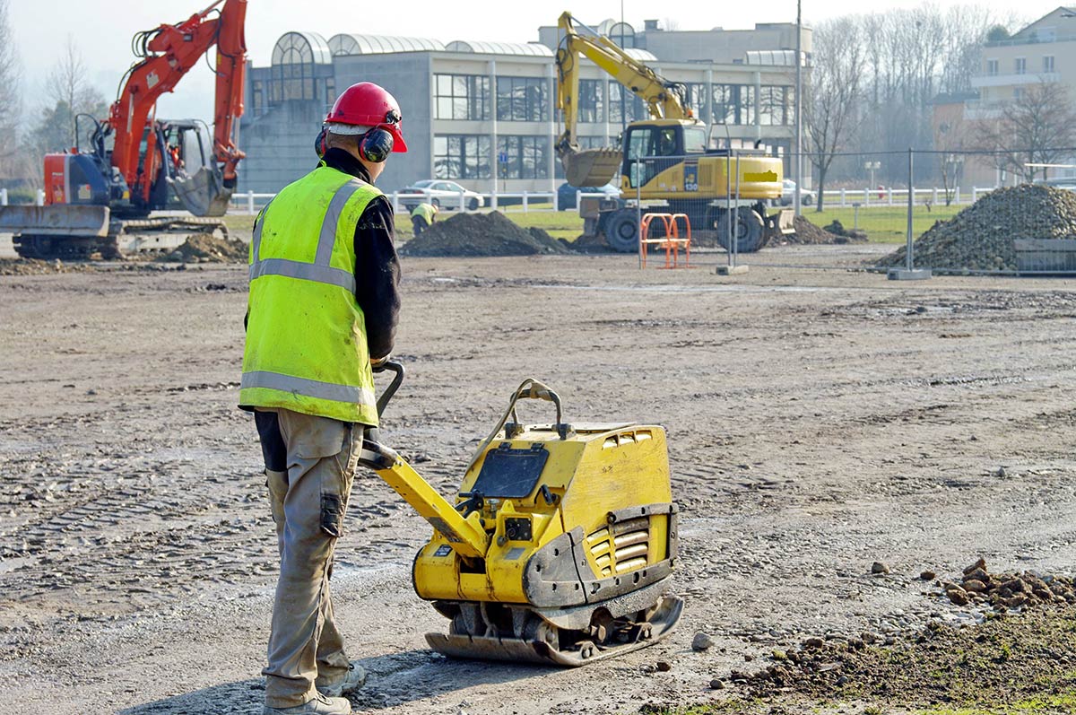 Ouvrier utilisant une plaque vibrante