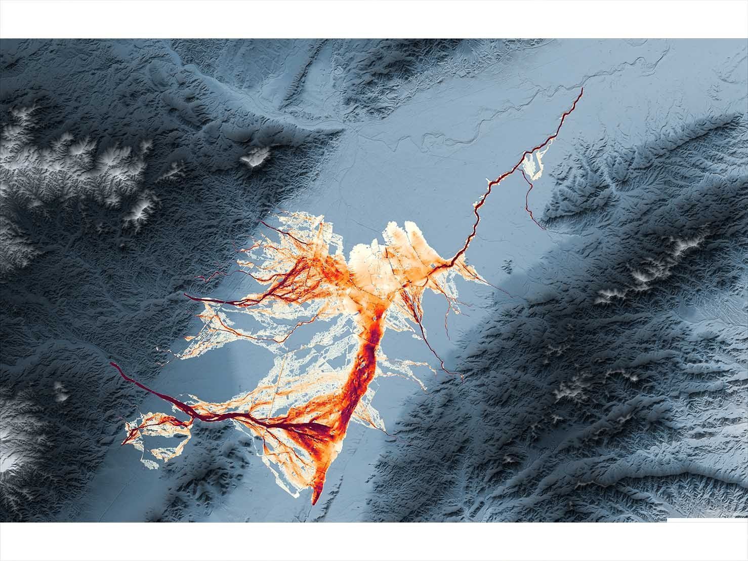Vista aérea de un paisaje nevado con una estructura arbórea de color naranja brillante que se ramifica hacia un río congelado.