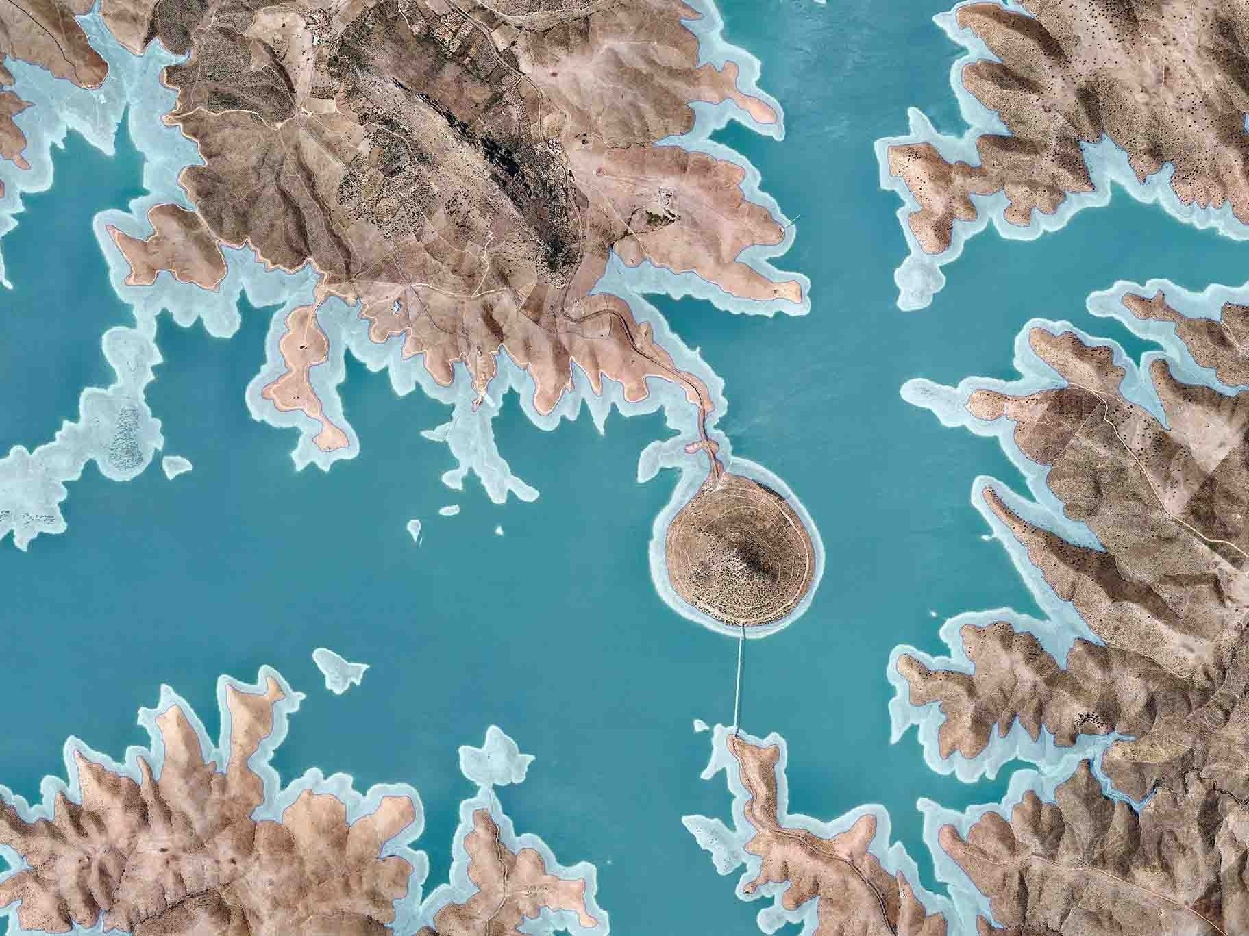 Vista aérea de un lago turquesa rodeado de islas rocosas, escarpadas y marrones.