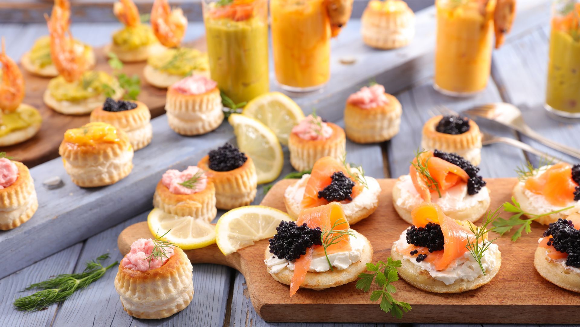 Assortiment d'amuse-bouche : crevettes, saumon, caviar et pâtisseries fourrées à la crème.