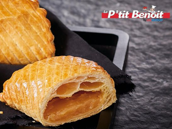 Deux pâtisseries dorées et feuilletées, à la croûte en treillis, sont posées sur un plateau noir.