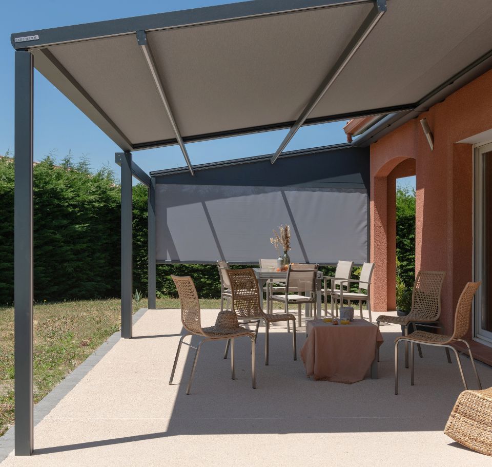 Terrasse avec pergola grise ombrageant une table et des chaises