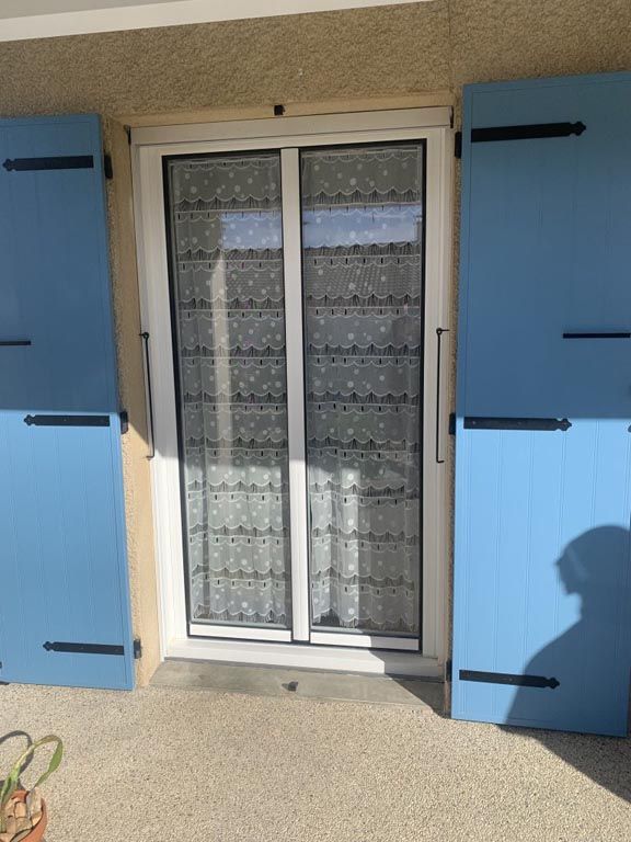 Porte-fenêtre blanche volets bois