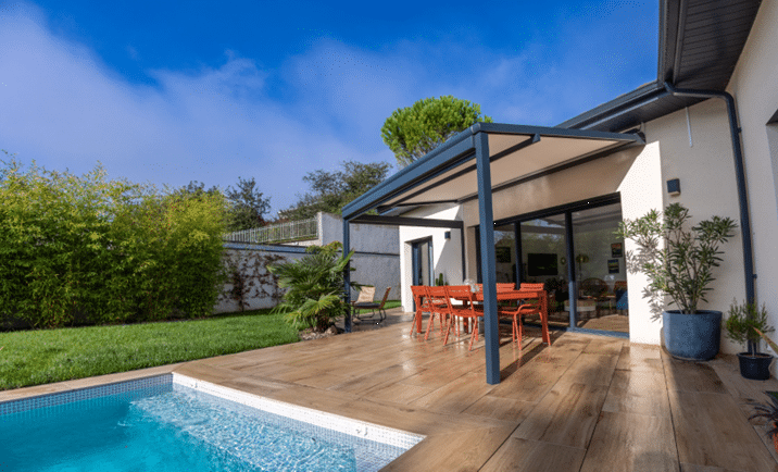 Terrasse arrière avec piscine, terrasse en bois et table à manger sous une pergola