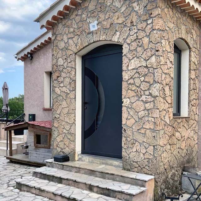 Porte d'entrée bleu marine maison en pierres apparentes
