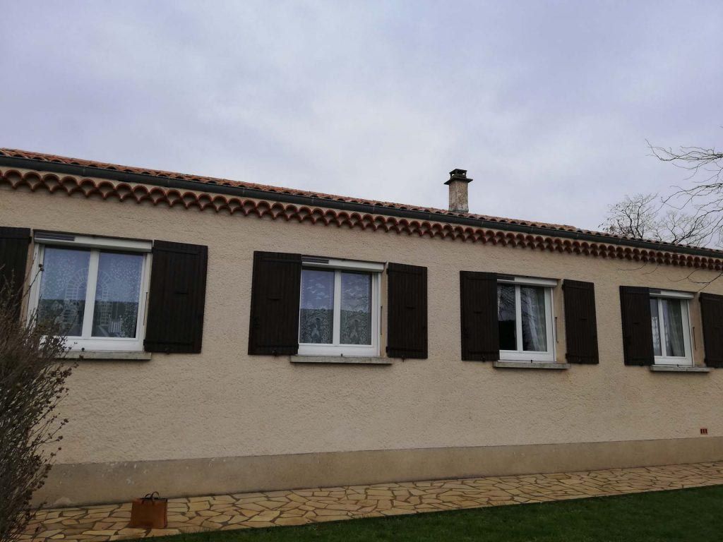 Façade avec quatre fenêtres, volets roulants et battants