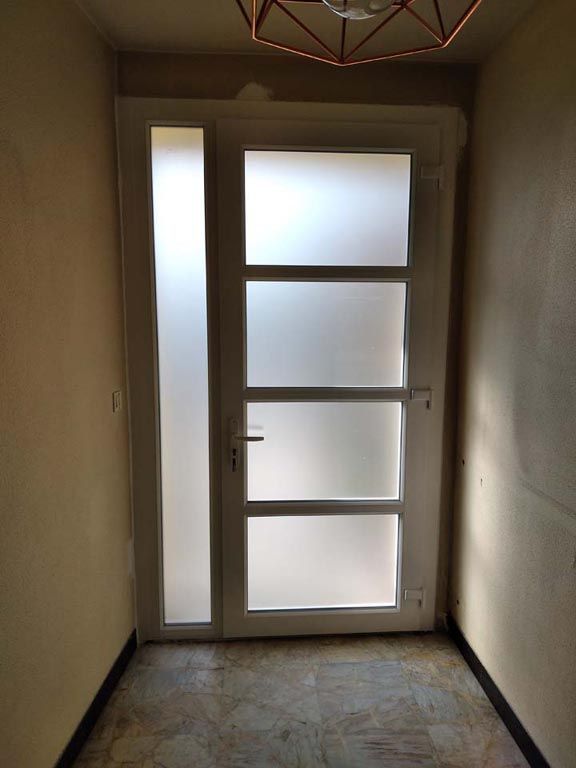 Porte d'entrée vitrée blanche, vue de l'intérieur