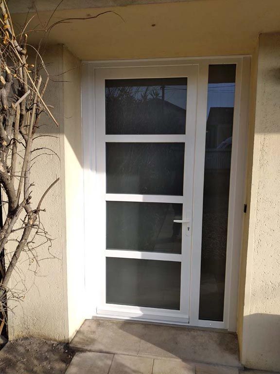 Porte d'entrée vitrée blanche, vue de l'extérieur