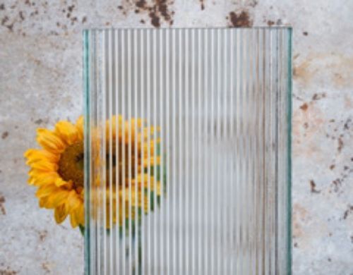 Profilglas Stück mit vertikalen Streifen im Hintergrund eine Sonnenblume