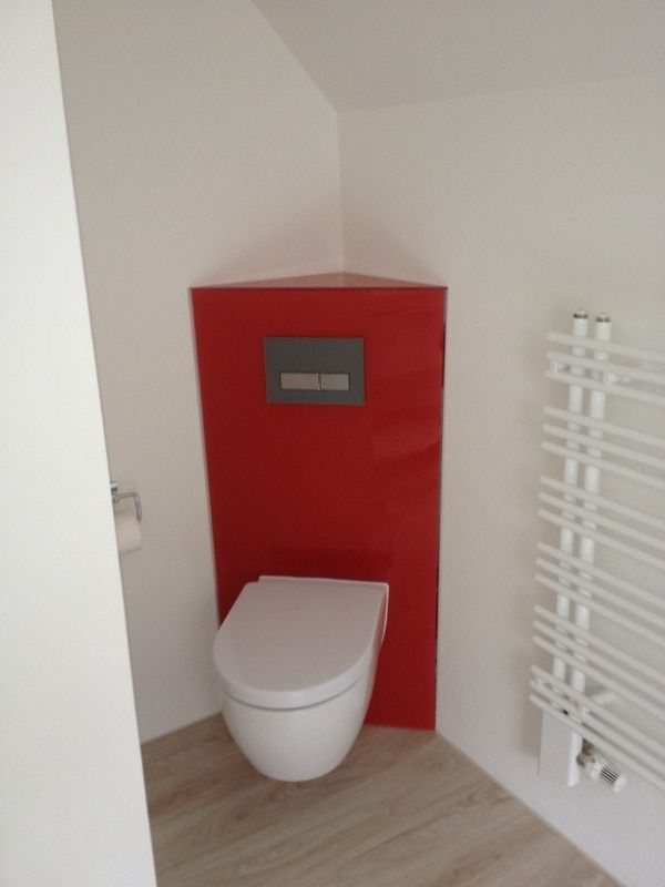 Weiße Toilette vor einer roten Glasrückwand