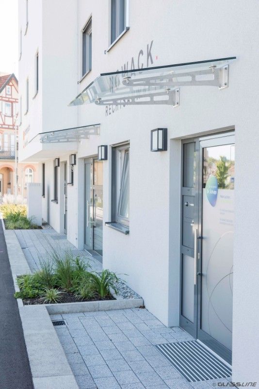 Gläsernes Vordach im Eingangsbereich eines Wohnhauses