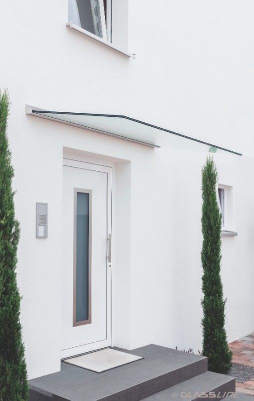 Glasvordach im Eingang eines weißen Hauses