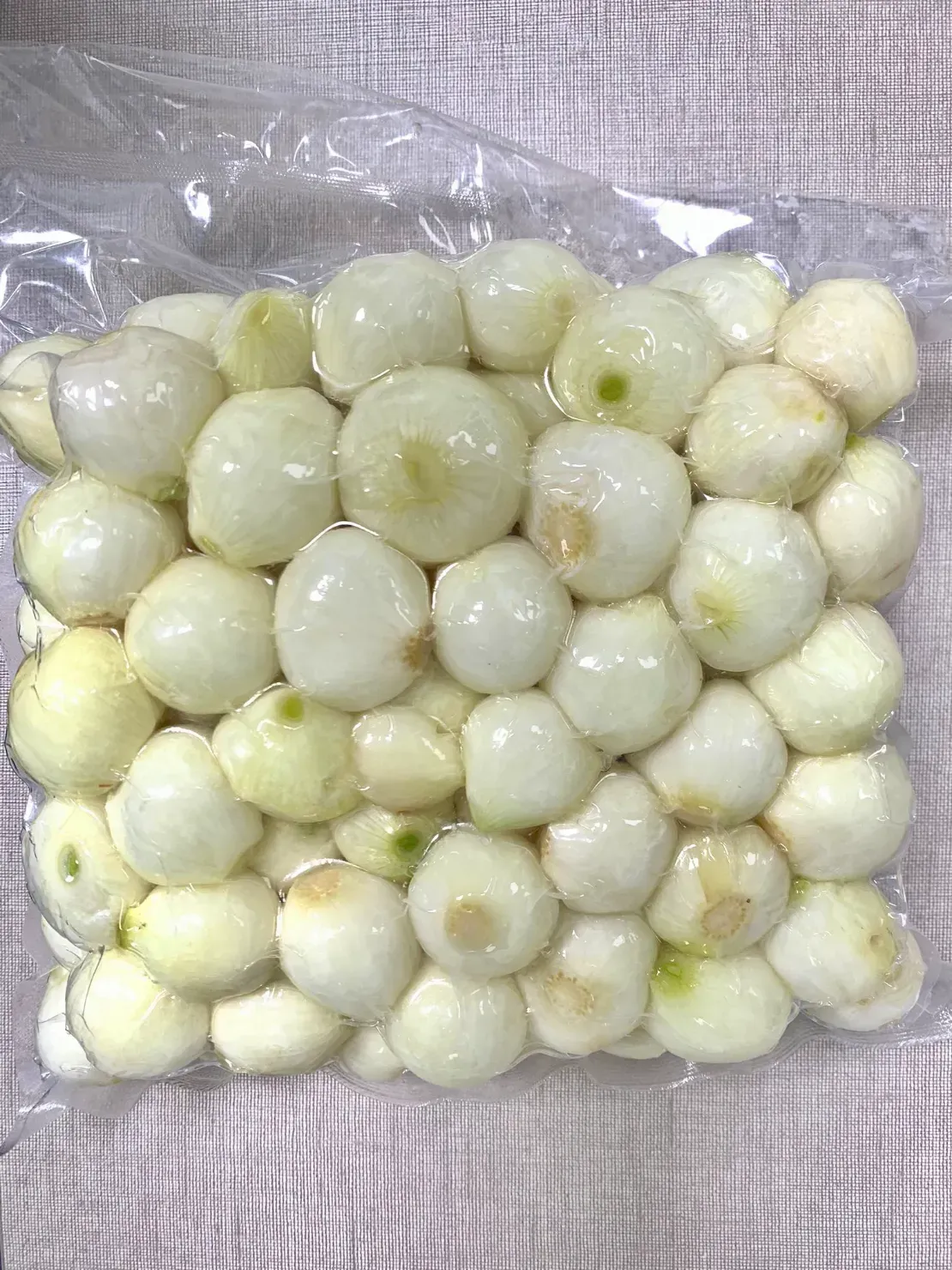 Una bolsa de cebollas está sobre una mesa.