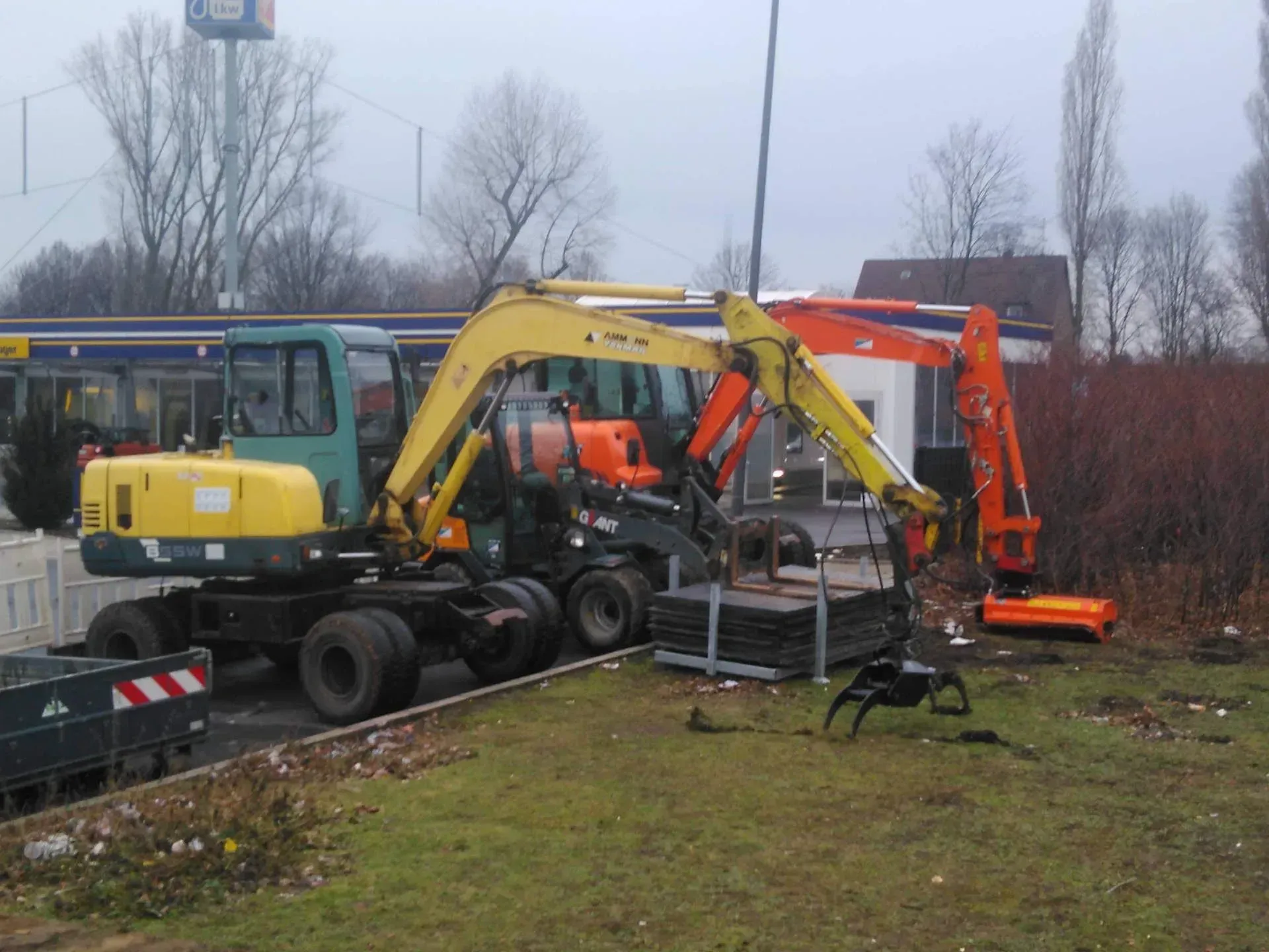 Ein gelber Bagger steht neben einem orangefarbenen Bagger