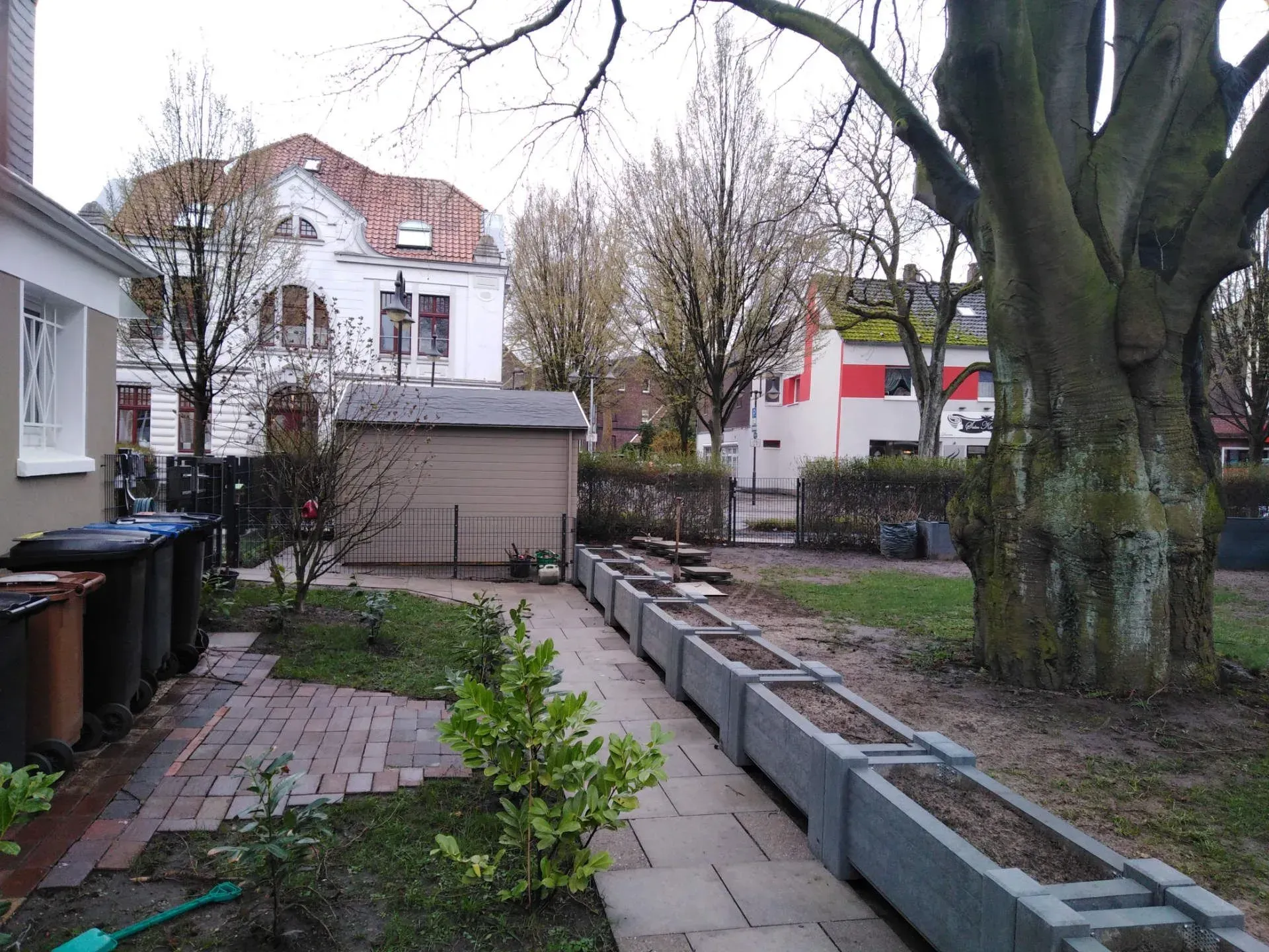 Eine Reihe von Pflanzgefäßen steht in einem Garten