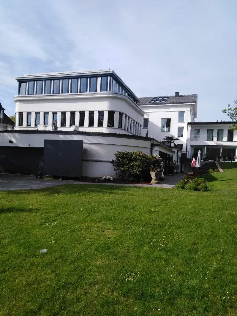 Ein großes modernes weißes Gebäude mit einem grünen Rasen