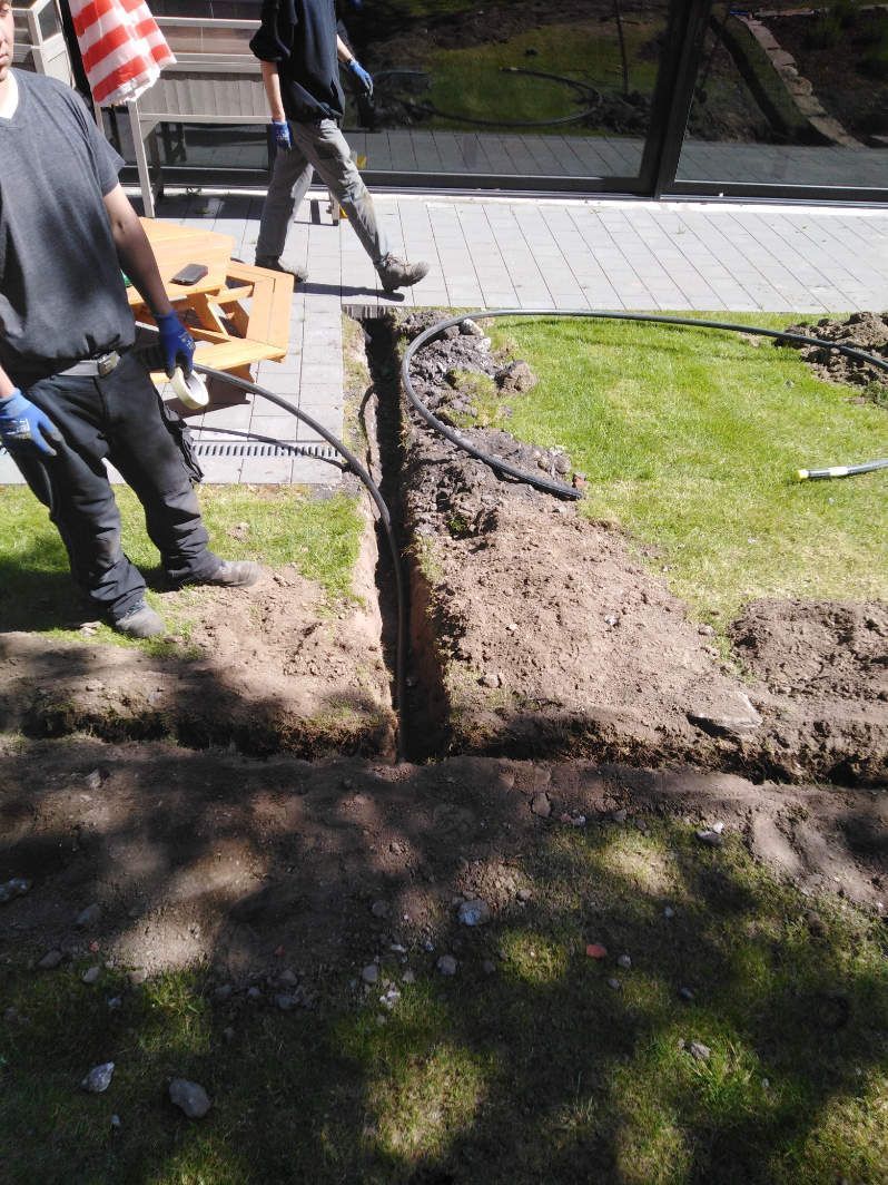 Ein Mann gräbt im Garten ​​ein Loch in den Boden zur Installation der Bewässerungsanlage