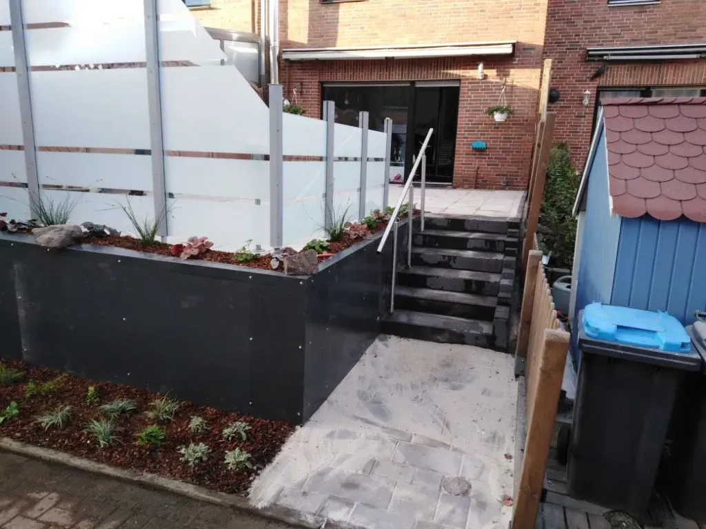 Ein Glaszaun und eine Treppe, die zu einem Backsteingebäude führt