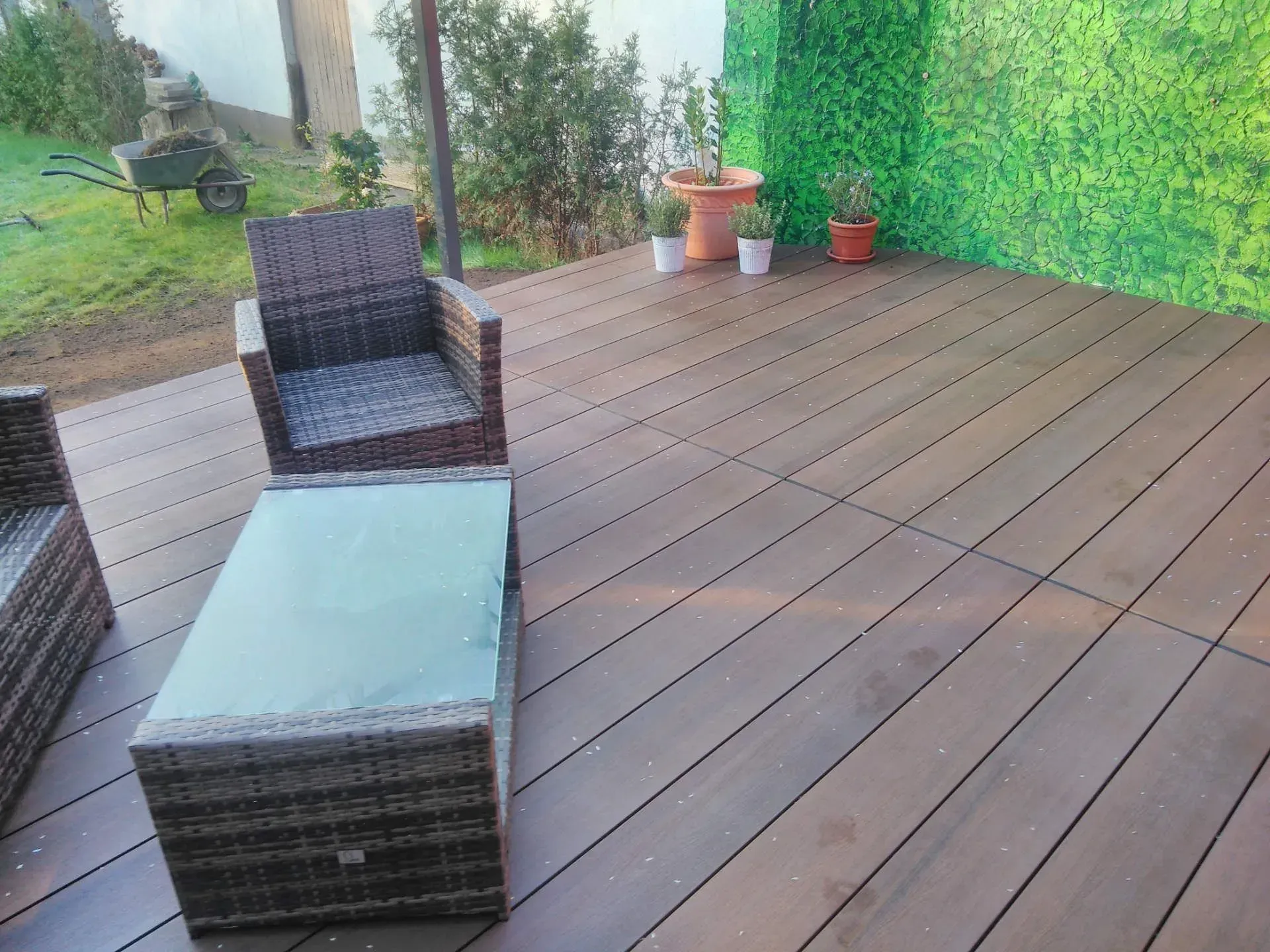 Eine Holzterrasse mit Stühlen und einem Tisch darauf