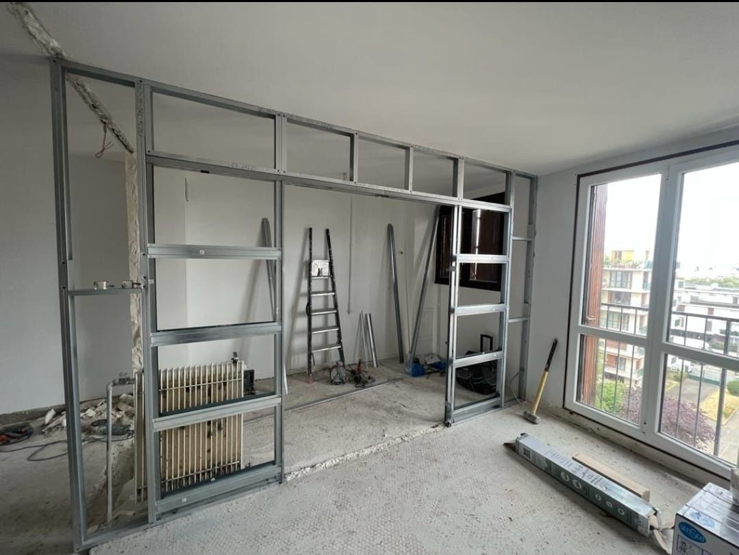 Estructura metálica de un muro interior en construcción; se ve una ventana.