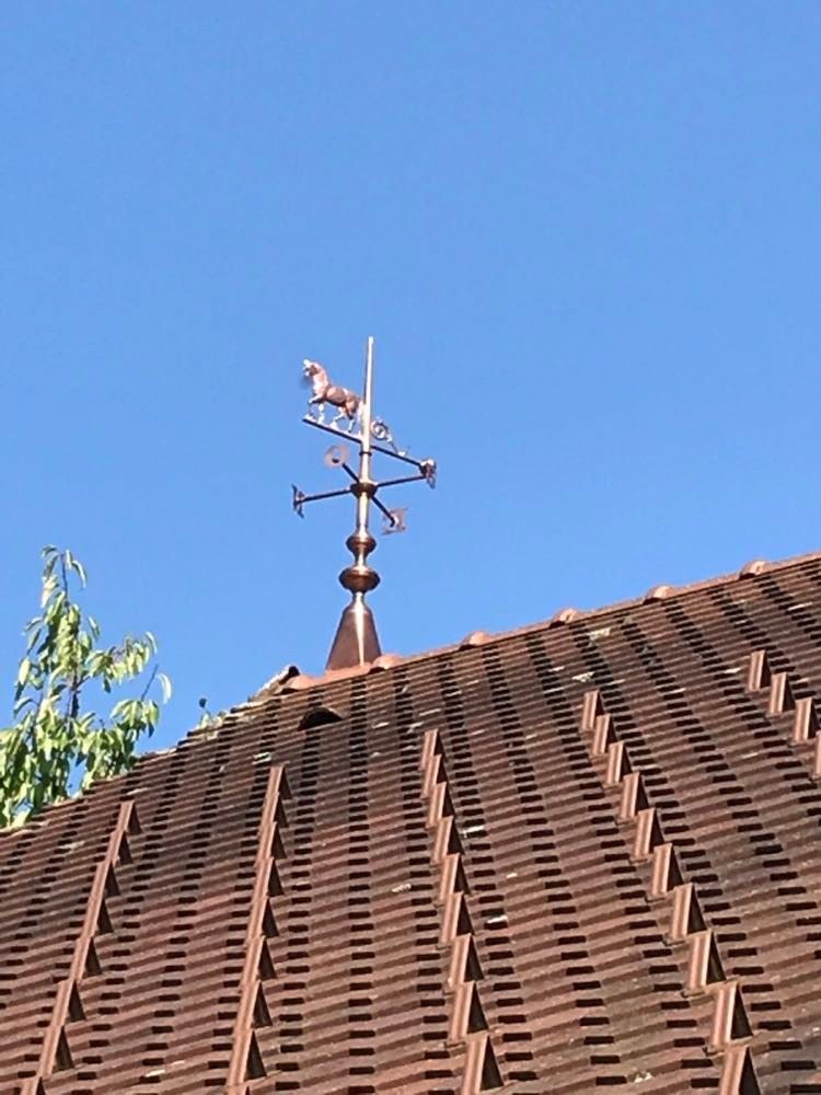Toit avec girouette sur fond de ciel bleu clair