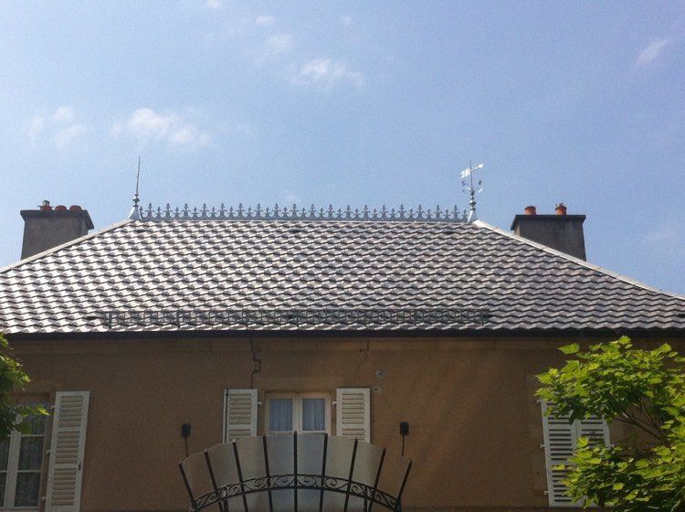 Maison au toit de tuiles grises et au ciel bleu, vue d'en bas