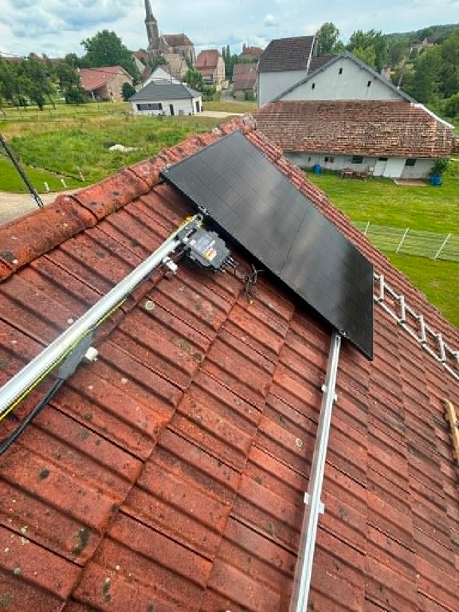 Panneau solaire installé sur un toit de tuiles rouges dans un village rural