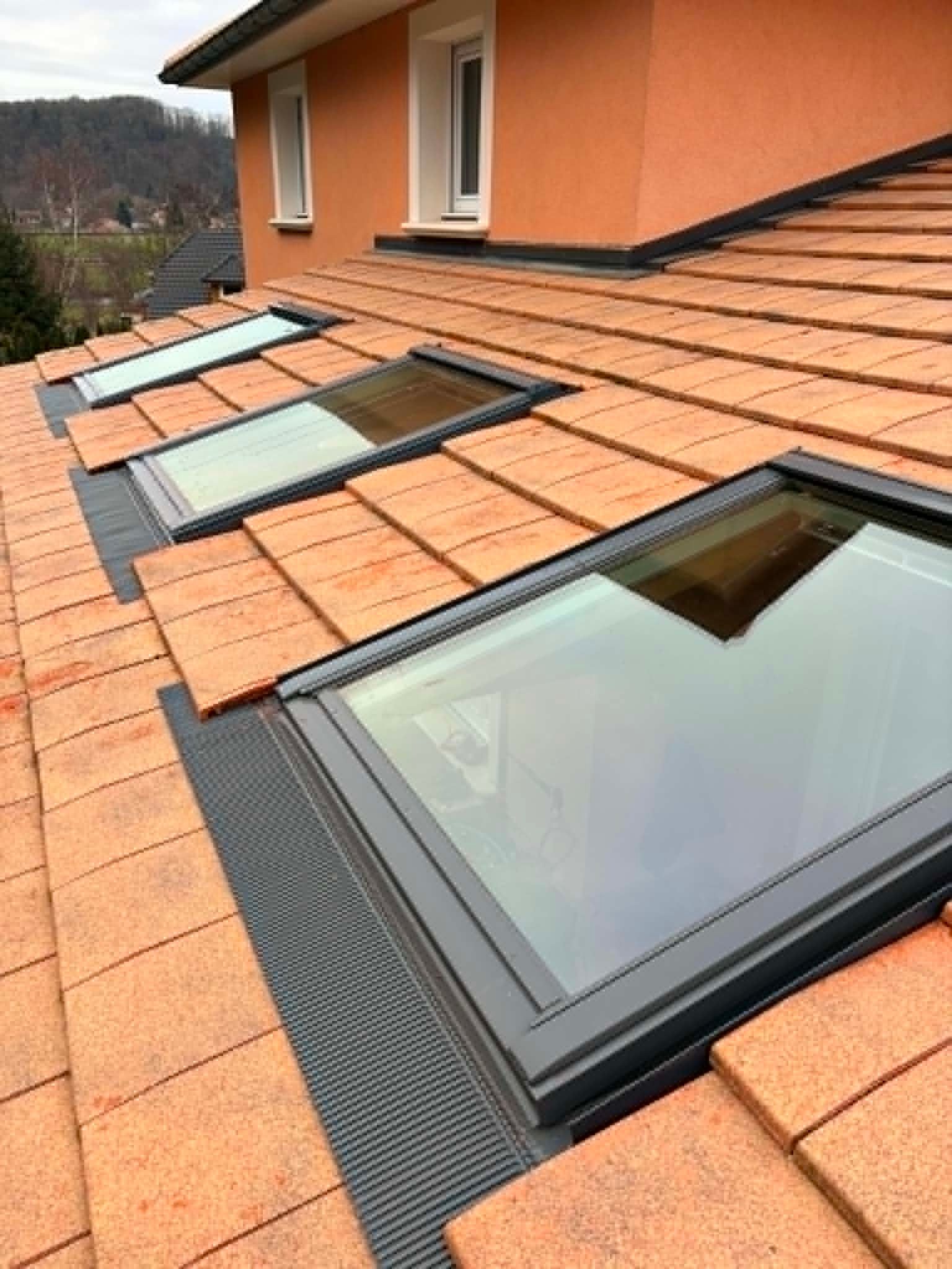 Toiture en tuiles orange et puits de lumière sur une maison moderne