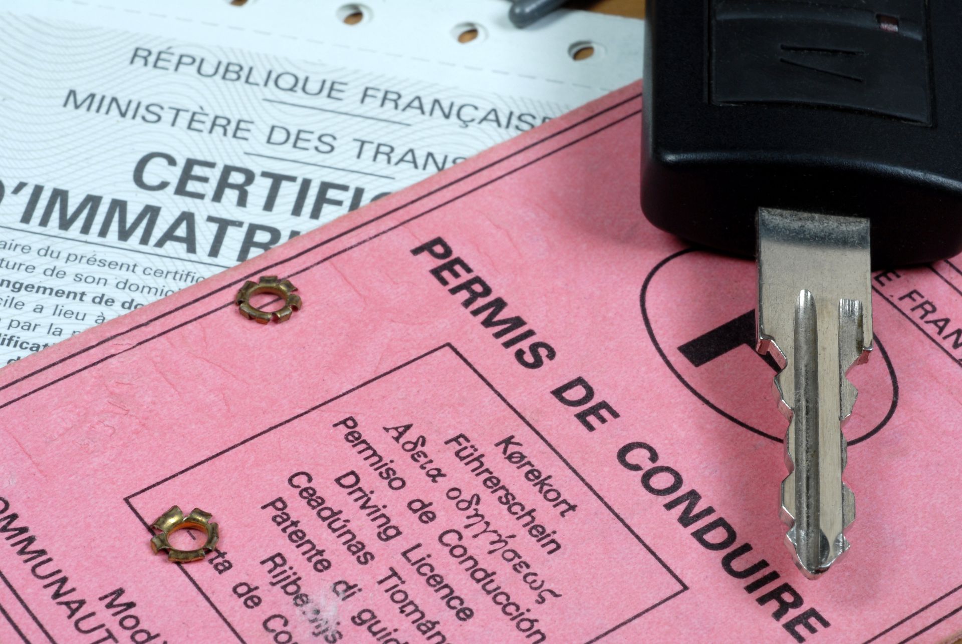 Permis de conduire français et carte grise du véhicule avec une clé de voiture en haut.