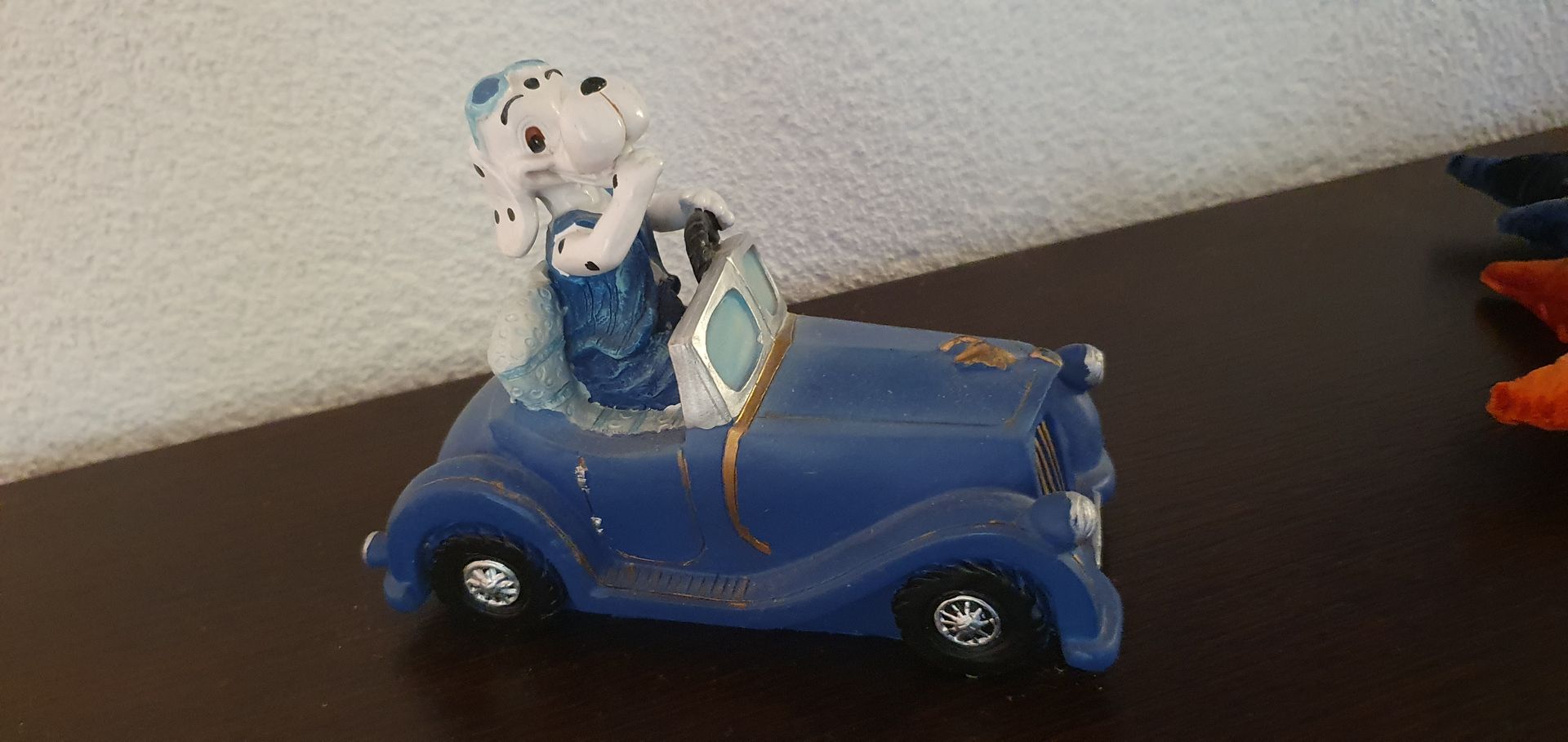 Gemütliches Dachzimmer mit blauem Futon, Holzmöbeln, Oberlicht und buntem Teppich.