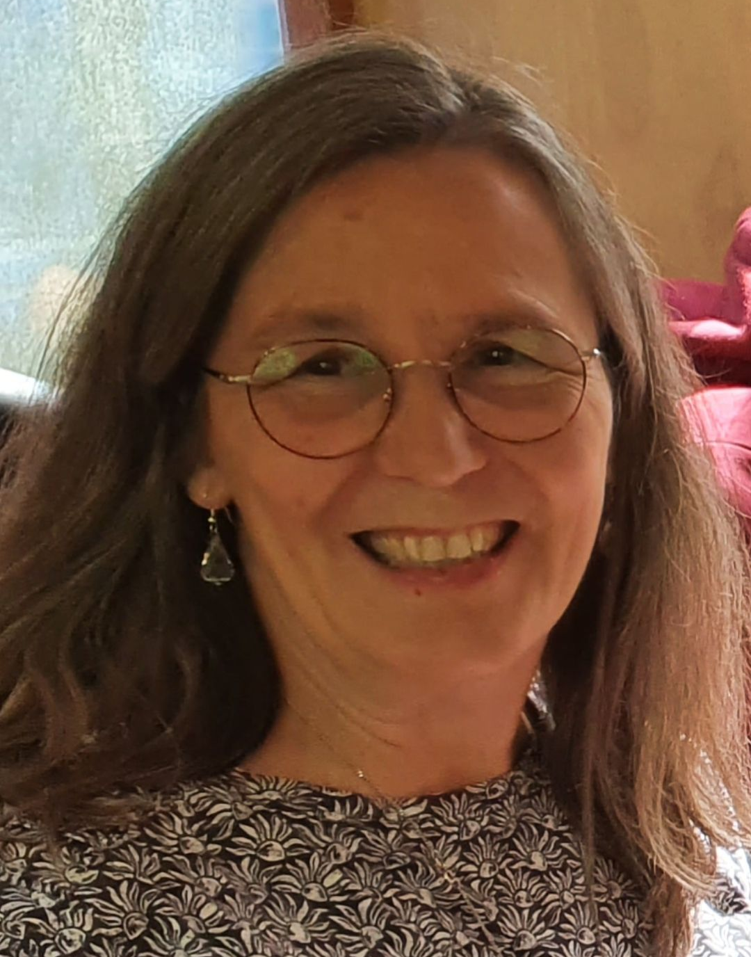 Spa-Raum mit Massagetisch, weißer Bettwäsche, Kerzen und Holzregalen.