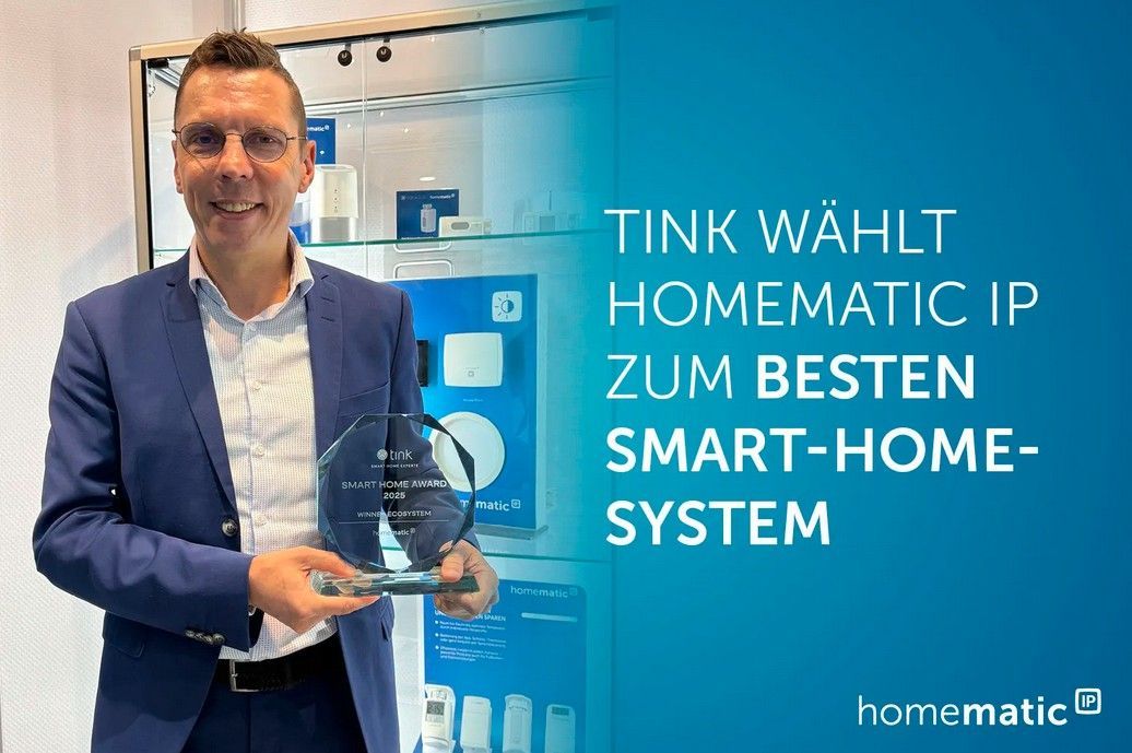 Mann hält eine Auszeichnung, Text „Homematic IP bestes Smart-Home-System“, blauer Hintergrund