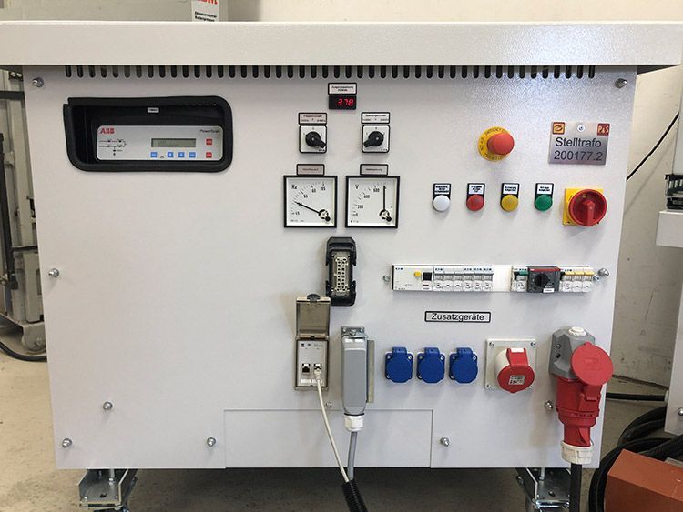Weißes elektrisches Bedienfeld mit verschiedenen Messgeräten, Schaltern und Steckdosen.