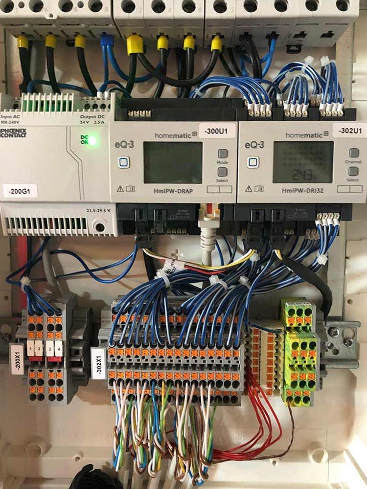 Bedienfeld mit elektrischer Verkabelung, Klemmen und Anzeigen.