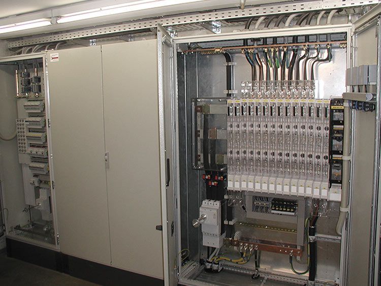 Geöffneter Elektroschrank mit verschiedenen Bauteilen und Verkabelung.