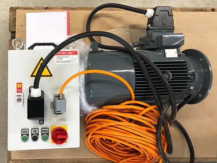 Elektromotor mit Bedienfeld, orangefarbenem Kabel und schwarzer Verkabelung.