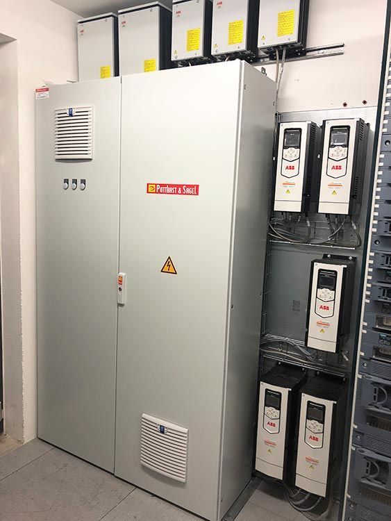 Schaltschrank mit mehreren ABB-Frequenzumrichtern und mehreren zusätzlichen Steuerungen.