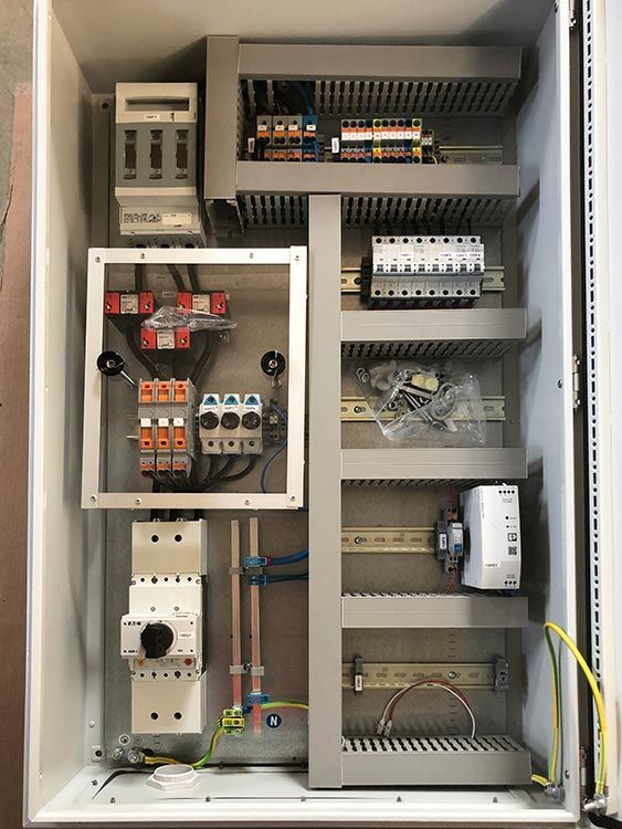 Elektrischer Schaltschrank mit Sicherungen, Schaltern und Verkabelung in einem Metallgehäuse.