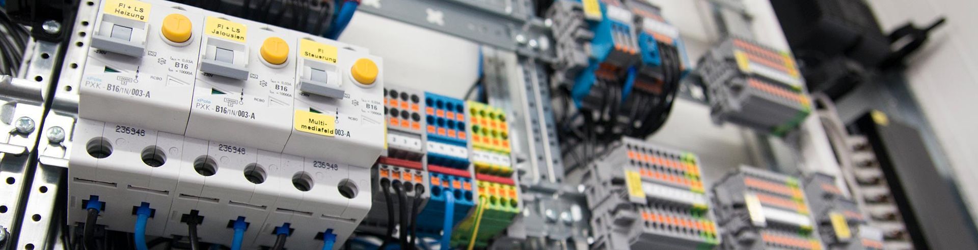 Elektrischer Schaltschrank mit mehrfarbigen Drähten und Bauteilen.