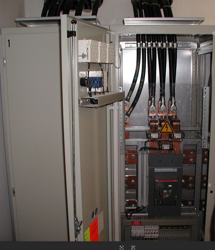 Schaltschrank mit offener Tür, der Kabel, Sicherungsautomaten und andere Bauteile in einem Metallgehäuse zeigt.