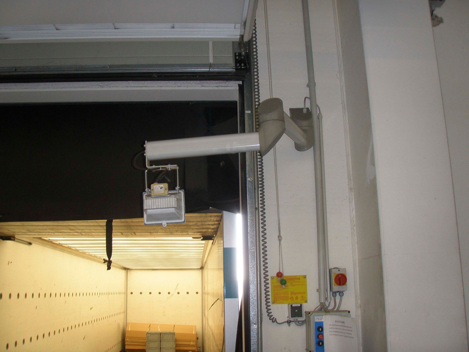 Laderampentor mit automatischem Arm und Bedienfeld.