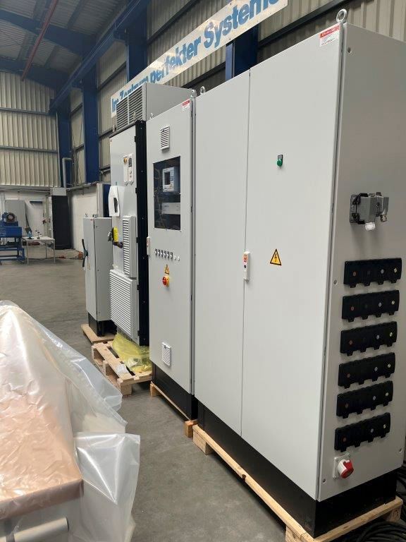 Graue Industrieschaltschränke auf Paletten in einem Lagerhaus.
