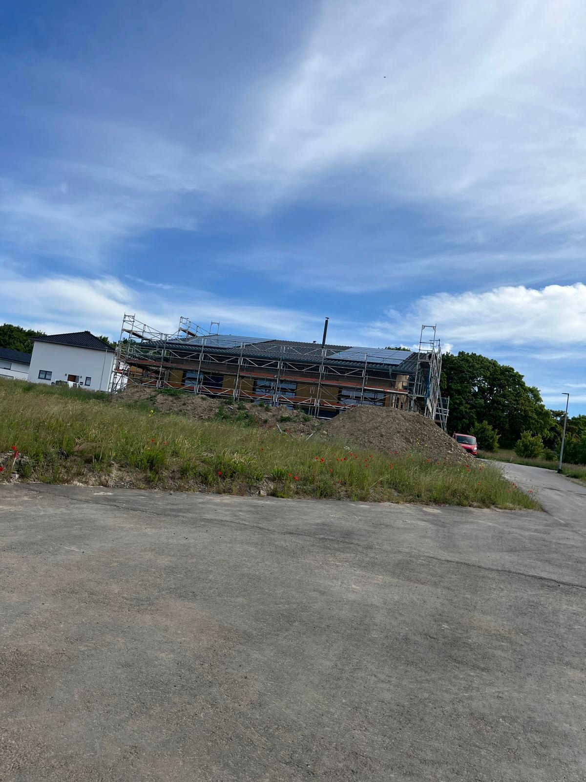 Abrissgelände auf einem grasbewachsenen Hügel; blauer Himmel mit Wolken.